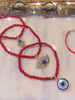 Trio Red Beaded Evil Eye charm stack bracelets.